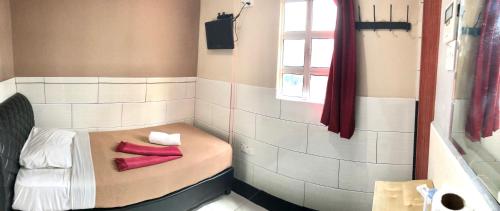 a small room with a bed with red socks on it at Adamson Park Kuala Lumpur in Kuala Lumpur