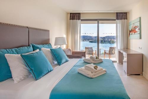 a bedroom with a large bed with blue and white pillows at Rodostamo Hotel & Spa- Adults Friendly in Kommeno