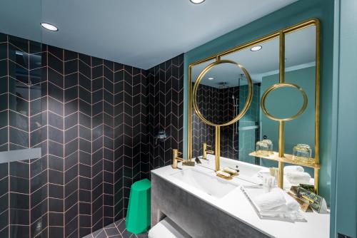 a bathroom with a sink and a mirror at Naumi Auckland Airport Hotel in Auckland