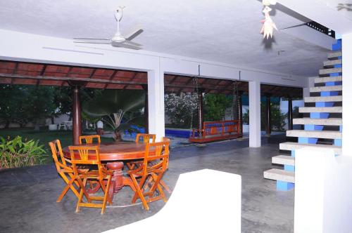 Une table et des chaises en bois sont disponibles sur la terrasse. dans l'établissement Villa Anna Pondy, à Pondichéry