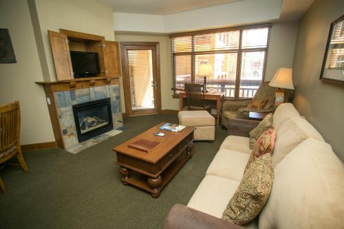 a living room with a couch and a fireplace at Sundial Lodge Condo Steps from Red Pine Gondola in Park City