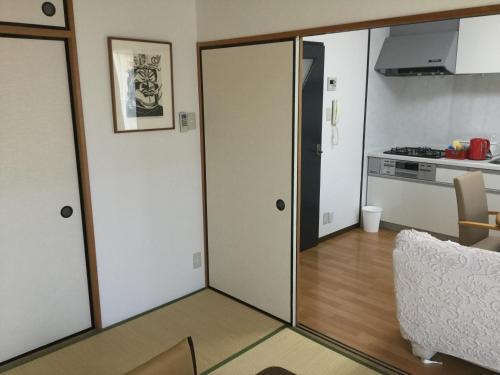 um quarto com uma porta de correr e uma cozinha em Gallery Compass em Osaka