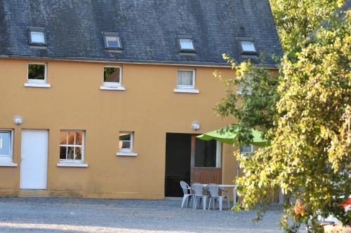 a house with chairs and a table in front of it at Gîtes de la terrette in Tribehou