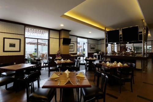 a restaurant with tables and chairs in a room at Amarelo Hotel Solo in Solo