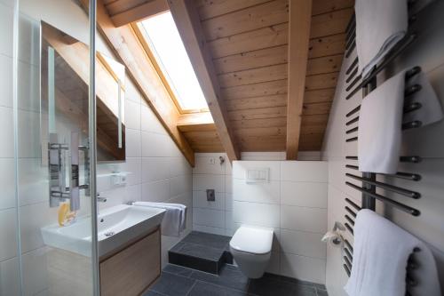 ein Badezimmer mit einem Waschbecken, einem WC und einem Dachfenster in der Unterkunft Ferienwohnung Fauser in Oberstdorf