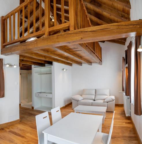 a living room with white furniture and wooden ceilings at Somo Garden Villas in Somo
