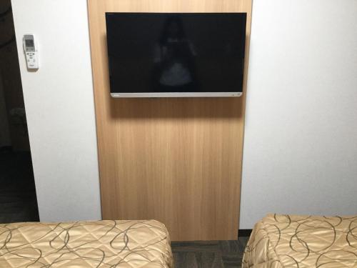 a television on a wall in a room at Maebashi Business Hotel Luka in Maebashi