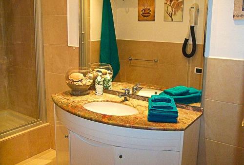 bagno con lavandino e doccia di The Golden Rainbow - SEAFRONT apartments a Villaggio San Leonardo