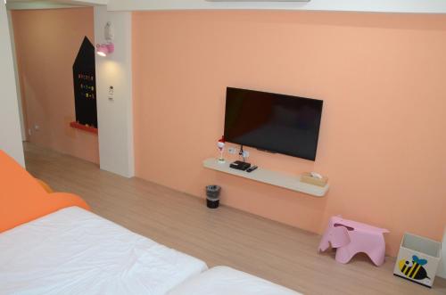 a bedroom with a bed and a flat screen tv at 胖蝸牛親子民宿 in Tainan