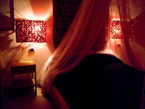 una camera da letto con letto con tende e luci di The Golden Rainbow - SEAFRONT apartments a Villaggio San Leonardo