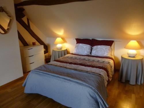 a bedroom with a large bed with two lamps at La Sauleraie in Frazé