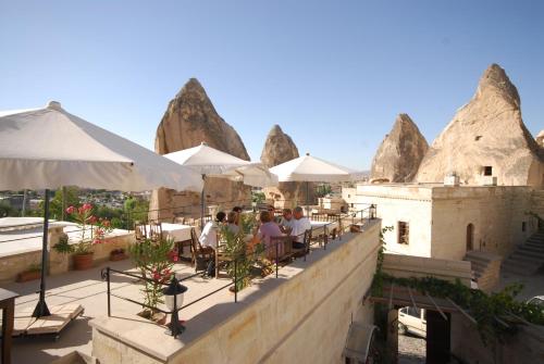 a restaurant with white umbrellas and people sitting at tables at Vezir Cave Suites in Goreme