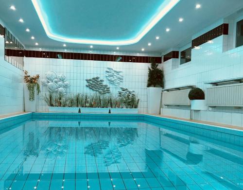 a large swimming pool with a blue ceiling at Kurhotel Wiedenmann in Bad Wörishofen