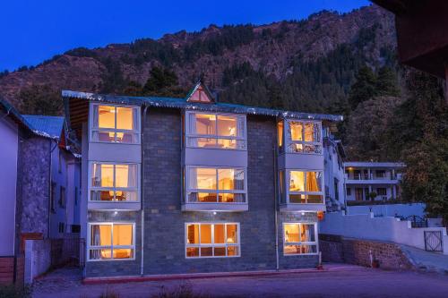 a large brick building with its lights on at The Pinewood, Nainital by Leisure Hotels in Nainital