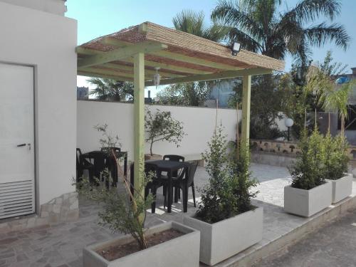 um pátio com uma mesa e cadeiras sob uma pérgola em Il Vicoletto em Casamassella