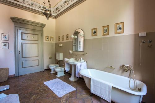 La salle de bains est pourvue de 2 lavabos, d'une baignoire et de toilettes. dans l'établissement Palazzo Salis - La Dimora del Conte, à Tirano