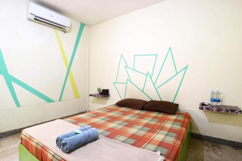 a bedroom with a bed and a painting on the wall at Wisma Gading Indah 1 in Jakarta