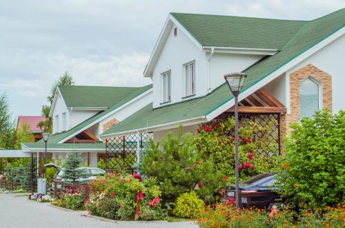 a white house with a green roof at Kapriz Issyk Kul Resort in Cholpon-Ata