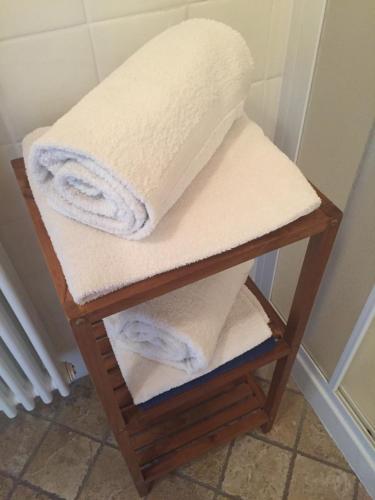 een stapel handdoeken op een plank in een badkamer bij Bed & Breakfast Col Mazzet in Belluno