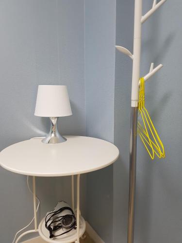 a white table with a lamp and a yellow lampshade at Seoul Forest Stay in Seoul