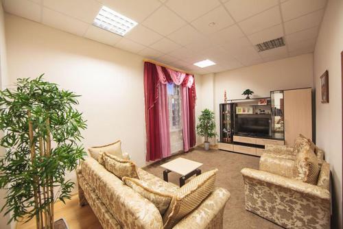 a living room with couches and potted plants at Hotel Orion in Surgut
