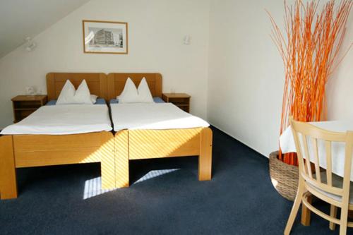 a bedroom with a wooden bed with white sheets and pillows at Penzion Luna in Brno
