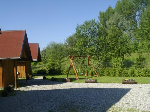 a playground in a yard with a wooden swing at Chaty Dagmar in Liptovský Mikuláš