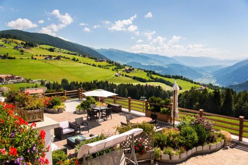 a patio with a table and chairs and flowers at Pension Wiesenrain in Maranza