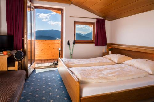 a bedroom with a bed and a large window at Pension Wiesenrain in Maranza