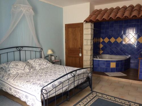 een slaapkamer met een bed en een bad bij La Mais'Ange in Berrias Et Casteljau