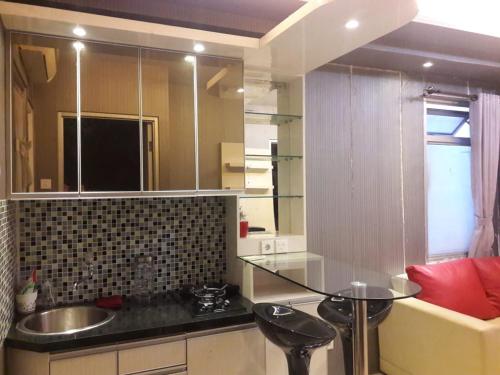 a kitchen with a sink and a table in a room at Apt Greenbay Baywalk Mall Pluit Seaside 2 Bedroom with Pool Facility in Jakarta