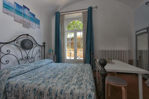 a bedroom with a bed and a table and a window at Magnolia Comfort & Rooms in Pisa