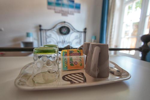 een dienblad met een bord met een glazen pot en een boek bij Magnolia Comfort & Rooms in Pisa