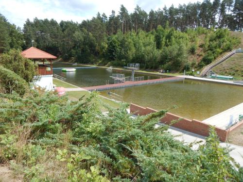 a pool of water with a gazebo and trees at Ferienhaus am Wald mit Klavier, Holzofen, Sauna in Alt Jabel