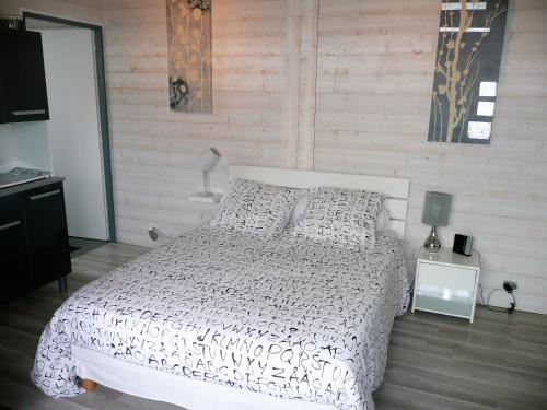 une chambre avec un lit blanc et un mur en bois dans l'établissement Studio BORDEAUX ST AUGUSTIN, à Bordeaux
