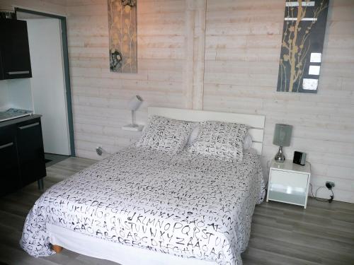 ボルドーにあるStudio BORDEAUX ST AUGUSTINの白いベッドと木製の壁が備わるベッドルーム1室が備わります。