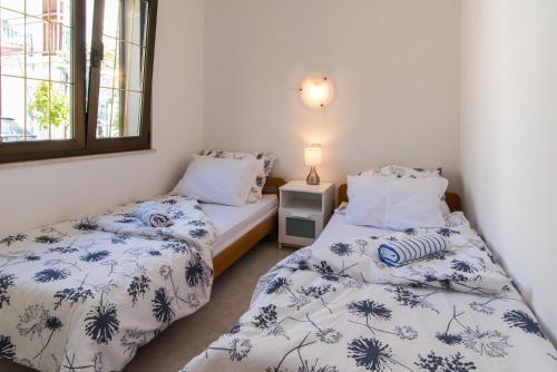 two twin beds in a room with white walls at apartman Babić in Krk