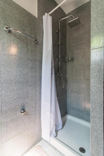 a shower with a white shower curtain in a bathroom at apartman Babić in Krk