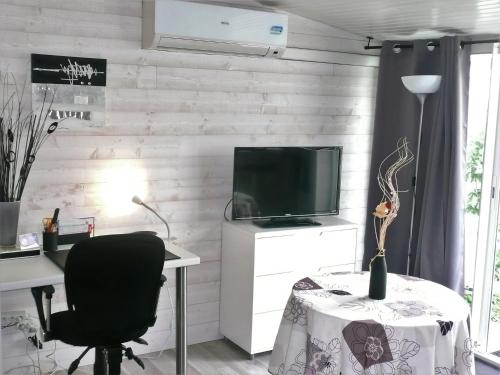 Cette chambre comprend un bureau, une télévision et une chaise. dans l'établissement Studio BORDEAUX ST AUGUSTIN, à Bordeaux