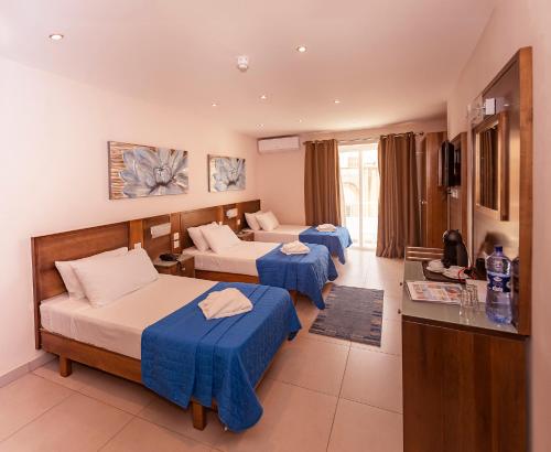 una camera d'albergo con due letti e un tavolo di Cerviola Hotel a Marsaskala