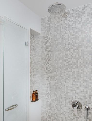a bathroom with a shower and a white tiled wall at Boutique Hotel Ani - Adults Only in Makarska