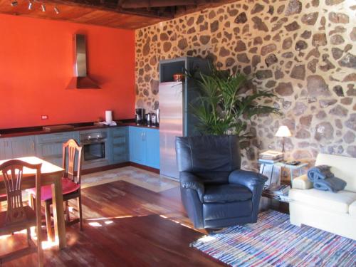 a kitchen with a refrigerator and a chair and a table at Haciendas del Valle - Las Kentias in Valle de Guerra
