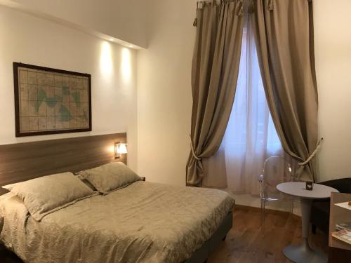Schlafzimmer mit einem Bett, einem Tisch und einem Fenster in der Unterkunft Casa Salbego B&B in Bologna