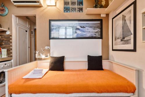 a bedroom with a large bed with an orange blanket at La Mole Sweet Studio in Turin