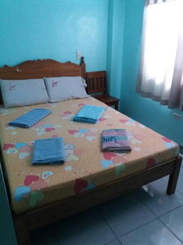 a bed in a room with towels on it at Eco Pension in Surigao