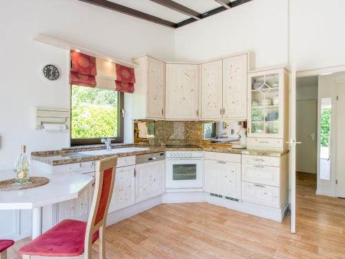 cocina con armarios blancos y encimera blanca en Detached bungalow in Kamperland near sea, en Kamperland