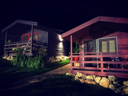 a log cabin at night with a fence in front at Enpi Lake Resort in Iaşi