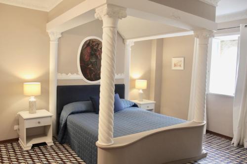 a bedroom with a canopy bed with a blue bed at Nettuno Suite in Siracusa