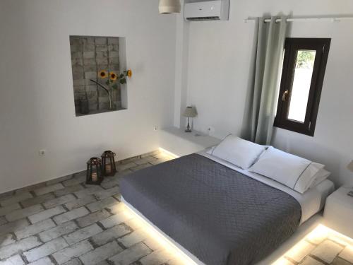 a bedroom with a bed in a room with a window at Elia Residences Santorini in Karterados