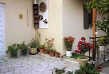 a room with potted plants on the side of a building at Villa Manolis in Tolo